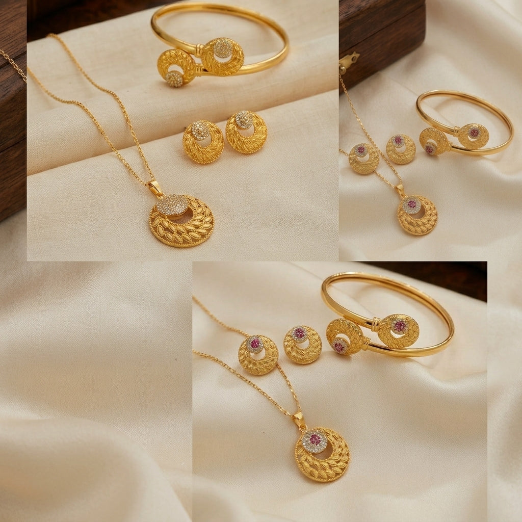 A gold jewelry set displayed in a collage on cream satin fabric, featuring a necklace with a textured circular pendant, matching stud earrings, and a slim bangle bracelet, each with a small pink gemstone accent.