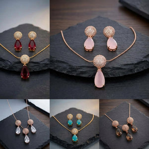 A 2x3 collage showing four different jewelry sets on dark slate trays: red teardrop earrings with round crystal tops and matching pendant, pale pink teardrop earrings with matching pendant, clear teardrop earrings with matching pendant, and brown teardrop earrings with matching pendant, all in gold-tone chains.